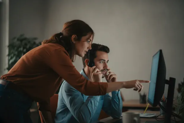 Support colleague leaning over to help with a customer case